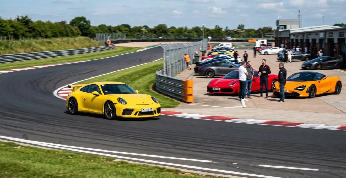 Voitures de sport sur circuit lors d'un track-day avec propriétaires passionnés dans le paddock